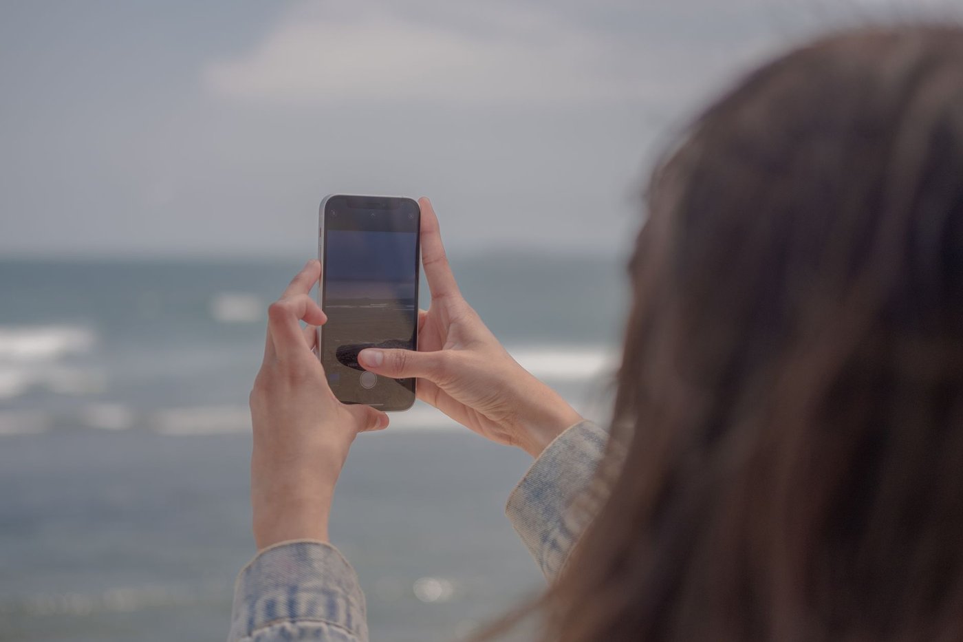 スマートフォンで写真をバックアップする女性